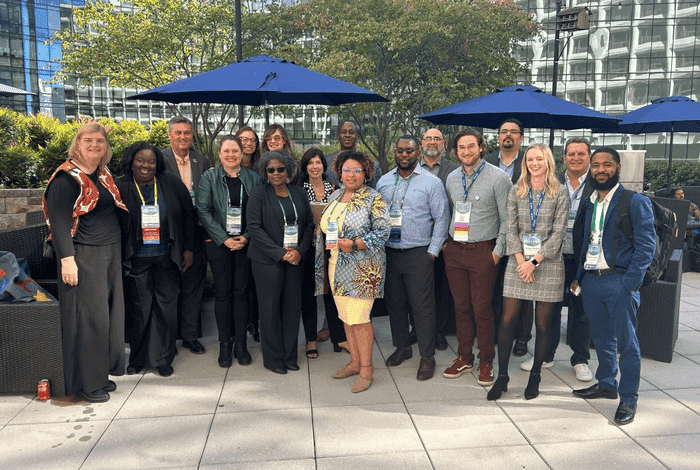 Diverse group of professionals smiling outdoors at a conference event.