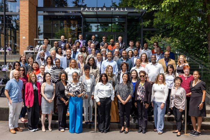 Diverse group of adults stands in front of Fallar Hall for a group photo.