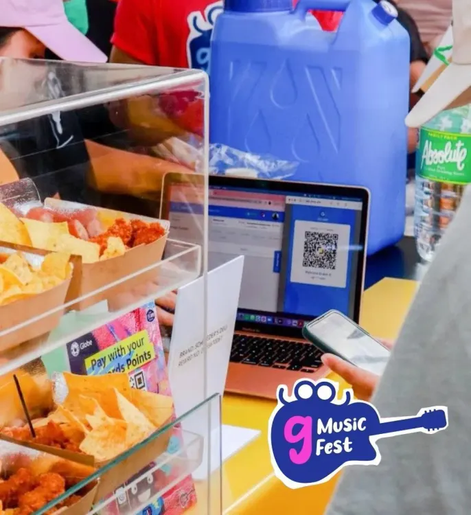 Concession stand selling snacks with a laptop displaying a QR code for digital payments.