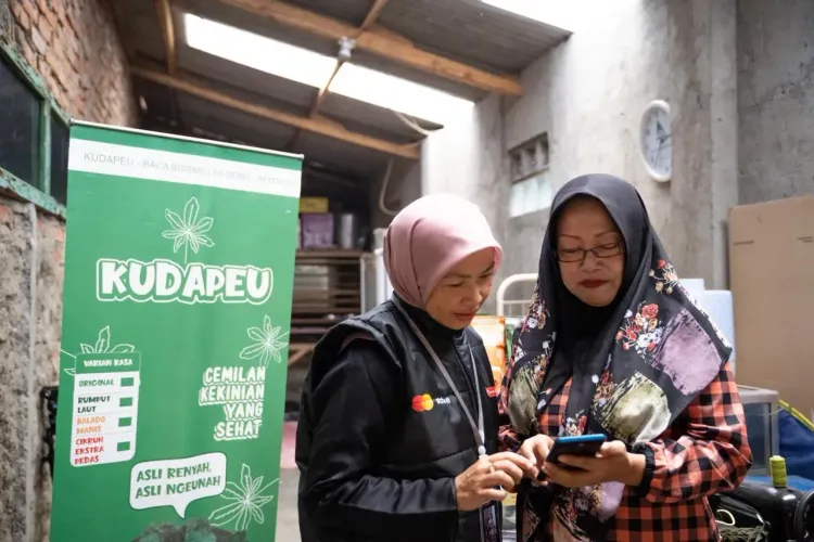 Enung (left) trains and mentors Mintarsih to boost her snack business in Garut. Mintarsih also became a part of Enung’s community, Rumah Kami (in English: Our Home).