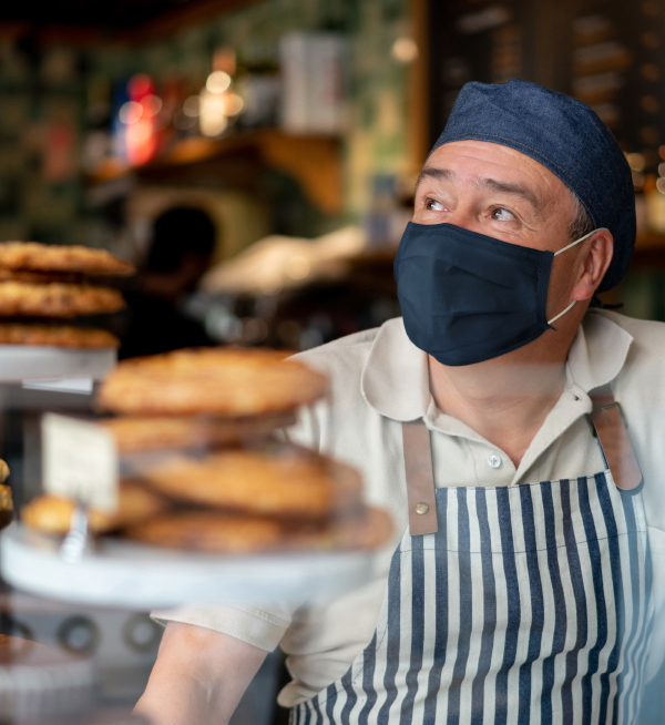 Man working at a coffee shop wearing a facemask