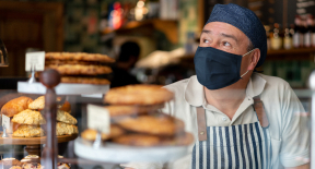 Man working at a coffee shop wearing a facemask